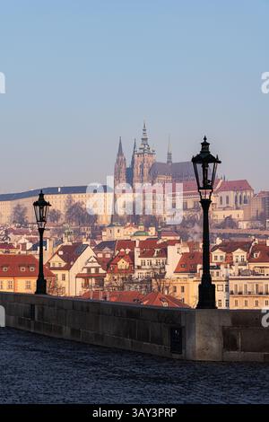 Ein ruhiger Blick auf die malerische Skyline Prags mit der berühmten Prager Burg, die an einem klaren Tag von einer Steinbrücke erfasst wurde. Stockfoto