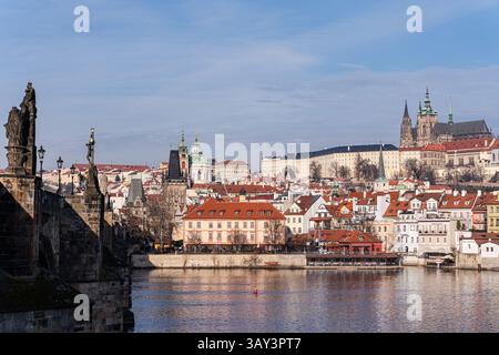 Ein malerischer Panoramablick auf die historische Skyline Prags, dominiert von der berühmten Prager Burg und den üppigen roten Dächern mit Skulpturen, die das C säumen Stockfoto