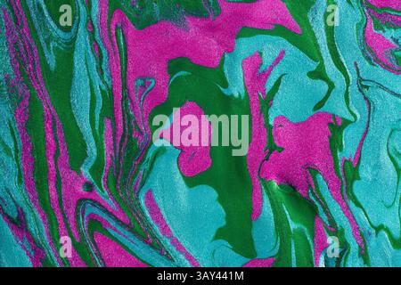 Ein Nahaufnahme-Bild mit wirbelnden Metallic-Farben, die Rosa- und Grüntöne mischen und einen lebendigen, strukturierten Hintergrund erzeugen. Stockfoto