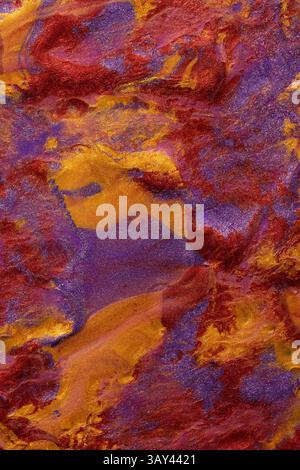 Nahaufnahme einer lebendigen, abstrakten Metallic-Farbmischung aus Rot-, Violett- und Goldtönen. Ideal für den Einsatz in künstlerischen Hintergründen und Designs. Stockfoto