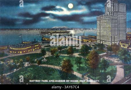 Der Battery Park und der Hafen von New York City werden nachts beleuchtet, und die Gebäude leuchten vor dem dunklen Himmel. Die Boote liegen an, während die Bäume aneinander liegen Stockfoto
