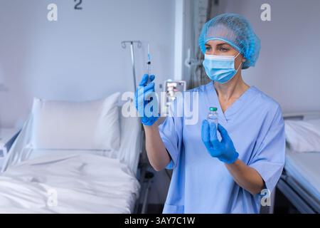 Krankenschwester bereitet die Injektion mit Spritze und Durchstechflasche im Krankenhausraum vor, Kopierraum Stockfoto