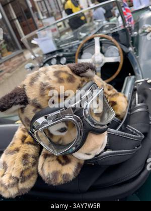 Ein Spielzeug-Jaguar mit Schutzbrille sitzt auf dem Faltverdeck eines Jaguar Motorwagens aus dem Jahr 1928, dem Coleford Festival of Transport. Stockfoto