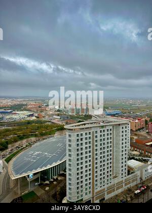 Eine breite Luftperspektive auf Valencias Vororte und moderne Hotelstrukturen unter bewölktem Himmel. Stockfoto