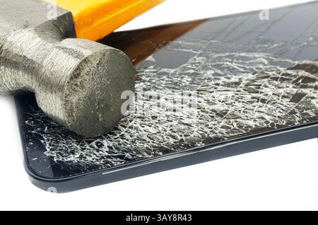 Ein Nahbild eines Hammers, der ein Smartphone zerschmettert, was zu einem stark zerrissenen und zersplitterten Bildschirm führt. Das Foto zeigt das Konzept des Geräts d Stockfoto