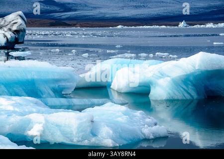Die ruhige Landschaft der Jökulsárlón Gletscherlagune in Island mit Eisbergen, die auf ruhigen Gewässern treiben, bietet eine atemberaubende und ruhige Szene von Islands Stockfoto