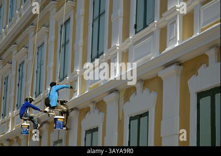 Bangkok , Thailand - 20. April 2025 : ein unbekannter Arbeiter, der am 20. April 2025 die Wände eines großen Gebäudes hängte, malte und reparierte Stockfoto