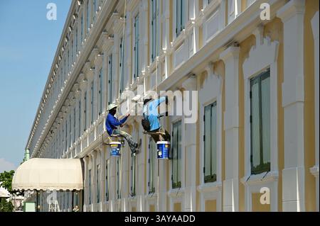 Bangkok , Thailand - 20. April 2025 : ein unbekannter Arbeiter, der am 20. April 2025 die Wände eines großen Gebäudes hängte, malte und reparierte Stockfoto