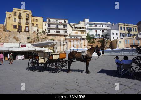 Pferdekutschen, die in einer Reihe im Hafen geparkt sind und darauf warten, dass Touristen die Stadt besichtigen. Hinten befindet sich die byzantinische Mauer mit Gebäuden Stockfoto