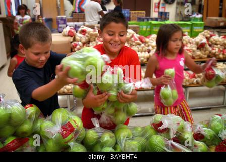 Schüler des Afterschool-Programms an der Eisenhut-Schule erhalten als Belohnung für Hausaufgaben und andere Aktivitäten Taschen mit Lebensmitteln für ihre Familien. Brandan Cordiero, Alex Sanches und Alexis Alba. September 2009. (Kreditbild: © Modesto Bee/ZUMA Press) Stockfoto