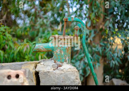 Alte Rusty Water Pump im Garten auf dem Land Stockfoto