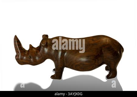 Ein traditionelles afrikanisches handgeschnitztes hölzernes Nashorn-Souvenir, isoliert vor einem weißen Hintergrund mit einem Schatten Stockfoto