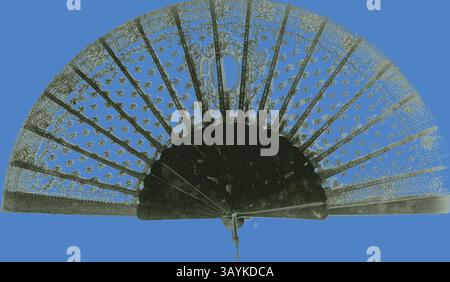 Ein aufwendig gestalteter Handventilator zeigt zarte Spitzenmuster und verzierte Details, ergänzt durch einen auffälligen blauen Hintergrund. Fan, ca. 1875, England, schwarze Schnürhalterung, glatte Schildkröte-Muschelstangen und -Schutzvorrichtungen, Muschelschlaufe und ein Metallniet, 26,7 cm 26,7 cm (10 1/2 Zoll) Klassische Kunst mit modernem Touch, neu interpretiert von Artotop Stockfoto