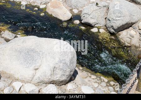 Tiefblauer Wasserstrom, der durch Felsen fließt Stockfoto