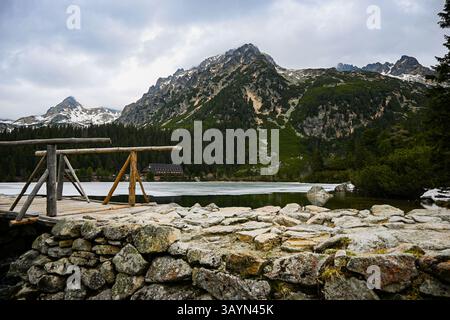 Schöner Bergsee Popradské pleso mit einer Berghütte, die die umliegenden Gipfel in der hohen tatra reflektiert, slowakei. Stockfoto