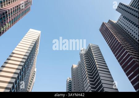 Niedriger Blickwinkel mit Blick auf moderne Bürogebäude und Wolkenkratzer vor klarem blauem Himmel. Stockfoto