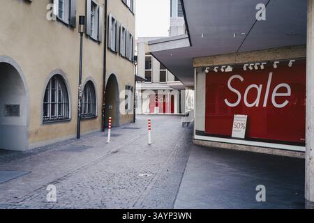 Verlassene Straße mit großen Verkaufsschildern in roten Schaufenstern in einer Stadt Stockfoto