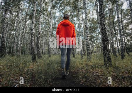 Frau, die durch den Wald wandert. Waldwanderweg Wanderer Frau, die im Herbst im Herbst Natur Hintergrund in der Herbstsaison geht. Wandern aktive Menschen Lifestyle exe Stockfoto