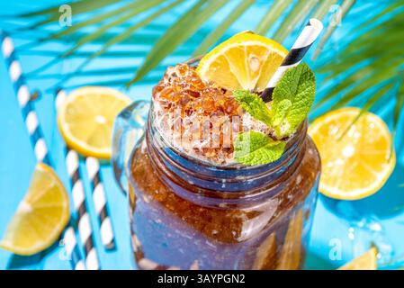 Südlicher Sweet Tea Slushy. Kalter Sommerteesüß-Dessert, hergestellt aus zerdrücktem Eistee und Zitronensaft, auf sonniger blauer Holzunterlage Stockfoto
