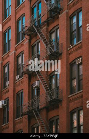 Es gibt ein gemauertes Gebäude mit einer Feuertreppe an der Seite Stockfoto