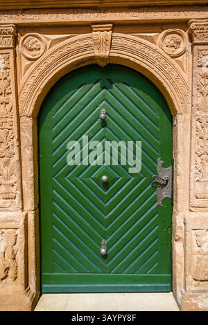 Alte grüne Holztür an einem alten Steingebäude. Stockfoto