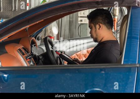 Bangkok, Thailand - 5. Mai 2017 : unbekannter Automechaniker oder Servicemitarbeiter, der einen Fahrzeugmotor mit OBD-II Elektrowerkzeugen auf Behebung und Reparatur eines Problems überprüft Stockfoto
