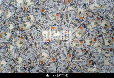 Eine chaotische Verteilung von US-Dollar-Scheinen füllt den Rahmen Stockfoto