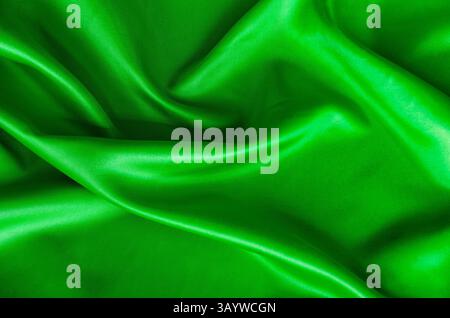 Poliertes dunkelgrünes Seidentuch mit seidenem Glanz und wunderschönen Naturdrapierungen. Geeignet für Design und Hintergrundtapeten. Stockfoto