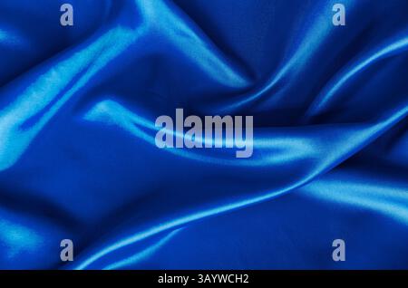 Poliertes blaues Seidentuch mit seidenweichem Glanz und wunderschönen Naturdrapierungen. Geeignet für Design und Hintergrundtapeten. Stockfoto