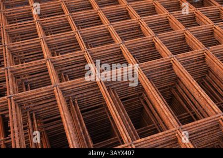 Die geschweißte, rostige Stahlverstärkung wird übereinander gelegt. Stockfoto