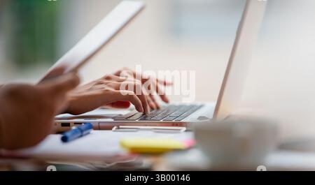 Junges asiatisches Glück mit Laptop-Computer im Café zur Arbeit. Vintage-Ton Stockfoto