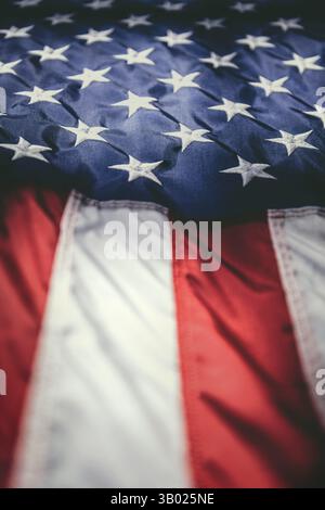 Bei einer Nahaufnahme werden die legendären Stars and Stripes der amerikanischen Flagge detailreich erfasst. Die leuchtenden roten und weißen Streifen fließen diagonal. Stockfoto