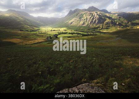 Ein atemberaubender Blick auf das Langdale Valley im Lake District mit dramatischem Side Pike Mountain und einer ruhigen ländlichen Landschaft rund um die Farm Stockfoto