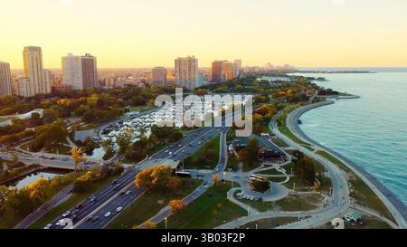 Chicago Lakefront Park und Marina bei Sonnenuntergang. Blick aus der Vogelperspektive auf das Chicago Seeufer mit Parkbereich, Yachthafen mit Booten, Hochhäusern und einem Stockfoto