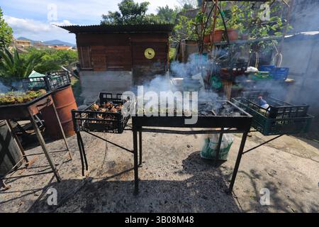 Frauen bei der Verarbeitung von gerösteten Artischocken typisches Gericht der kulinarischen Tradition Süditaliens in der Osterzeit. Stockfoto