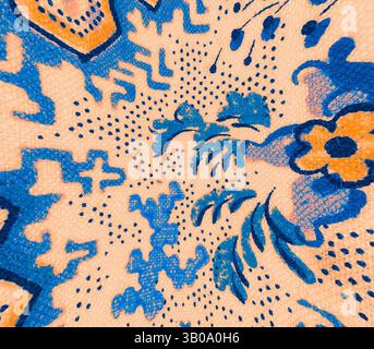 Die Nahaufnahme zeigt ein kompliziertes Textilmuster mit leuchtend blauen Blumenmustern, durchsetzt mit geometrischen Formen, vor einem weichen pfirsichfarbenen Hintergrund. Die kunstvollen Details und die wirbelnden Motive schaffen eine visuell fesselnde und lebendige Komposition. Ein kreisförmiges Textildesign mit komplexen Mustern in leuchtendem Blau und Orange auf einem warmen Hintergrund, das florale Motive und abstrakte Formen präsentiert. Klassische Kunst mit einem modernen Twist von Artotop, transformierte französische Stoffe, erste Hälfte des 19. Jahrhunderts, klassische Kunst mit einem modernen Twist von Artotop Stockfoto