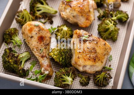 Im Ofen gebratenes Hähnchen mit Brokkoli auf einer Pfanne, einfaches Abendessen oder Mittagessen Stockfoto