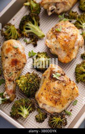 Im Ofen gebratenes Hähnchen mit Brokkoli auf einer Pfanne, einfaches Abendessen oder Mittagessen Stockfoto