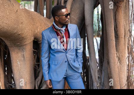Afroamerikanischer Geschäftsmann mit stilvollem blauem Anzug und trendiger Sonnenbrille Stockfoto