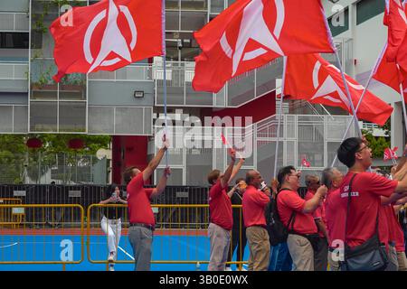 Singapur 23. April 2025 - Anhänger der SDP wurden vor der Chongfu-Schule am Nominierungstag während der Parlamentswahlen in Singapur mit roten Parteiflaggen verkleidet Stockfoto