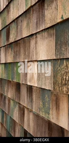 Rustikale Holz-Schindelwand aus Naturholz und verblasster grüner Farbe geometrisch geformte Schindeln an der Seite des alten Gebäudes in einem Winkel zu schaffen Stockfoto