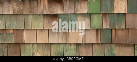 Horizontales Farbbild von verblassten grün blau lackierten Holzschindeln oder Schütteln an der Außenwand des alten Gebäudes und Schindeln in Reihen Stockfoto