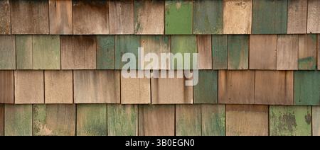 Horizontales Farbbild von verblassten grün blau lackierten Holzschindeln oder Schütteln an der Außenwand des alten Gebäudes und Schindeln in Reihen Stockfoto