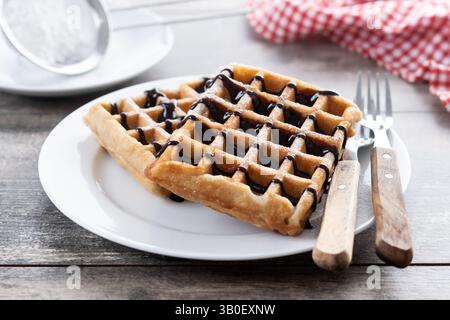 Belgische Waffeln mit Schokolade auf Holztisch Stockfoto