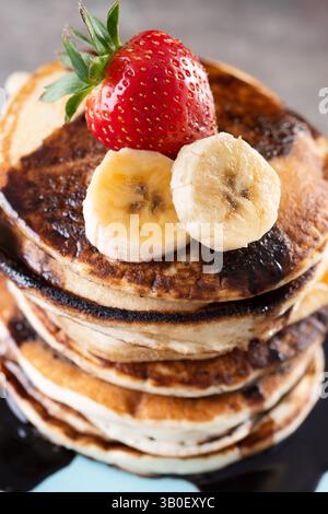 Pfannkuchen mit Schokolade und Obst auf Holztisch Stockfoto