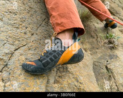 Eine Nahaufnahme der Füße an einer Kletterwand, eine beliebte Übung zum Aufbau von Kraft, Taktik, Entschlossenheit und Ausdauer in der Natur – Stockfoto Stockfoto