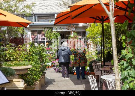 Bowral Stadtzentrum, Green Lane Einkaufs- und Restaurantviertel, zwei Damen gehen in Richtung Potting Shed Nursery and Plants Centre, NSW, Australien Stockfoto