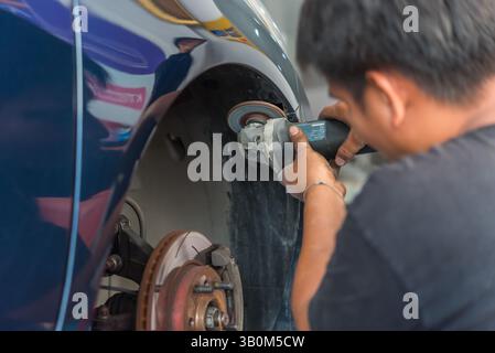 Bangkok, Thailand - 13. Januar 2018 : ein unbekannter Automechaniker oder Servicemitarbeiter überprüft und repariert Karosserieteil für neue Autoschürze in der Autogarage oder Stockfoto