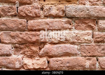 Nahaufnahme der verwitterten roten Ziegelmauer Stockfoto