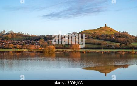 Ein Blick auf Glastonbury Tor im Winter am frühen Morgen von der Kuhbrücke über überflutete Felder von Lower Actis. Glastonbury, Somerset, England, Großbritannien Stockfoto
